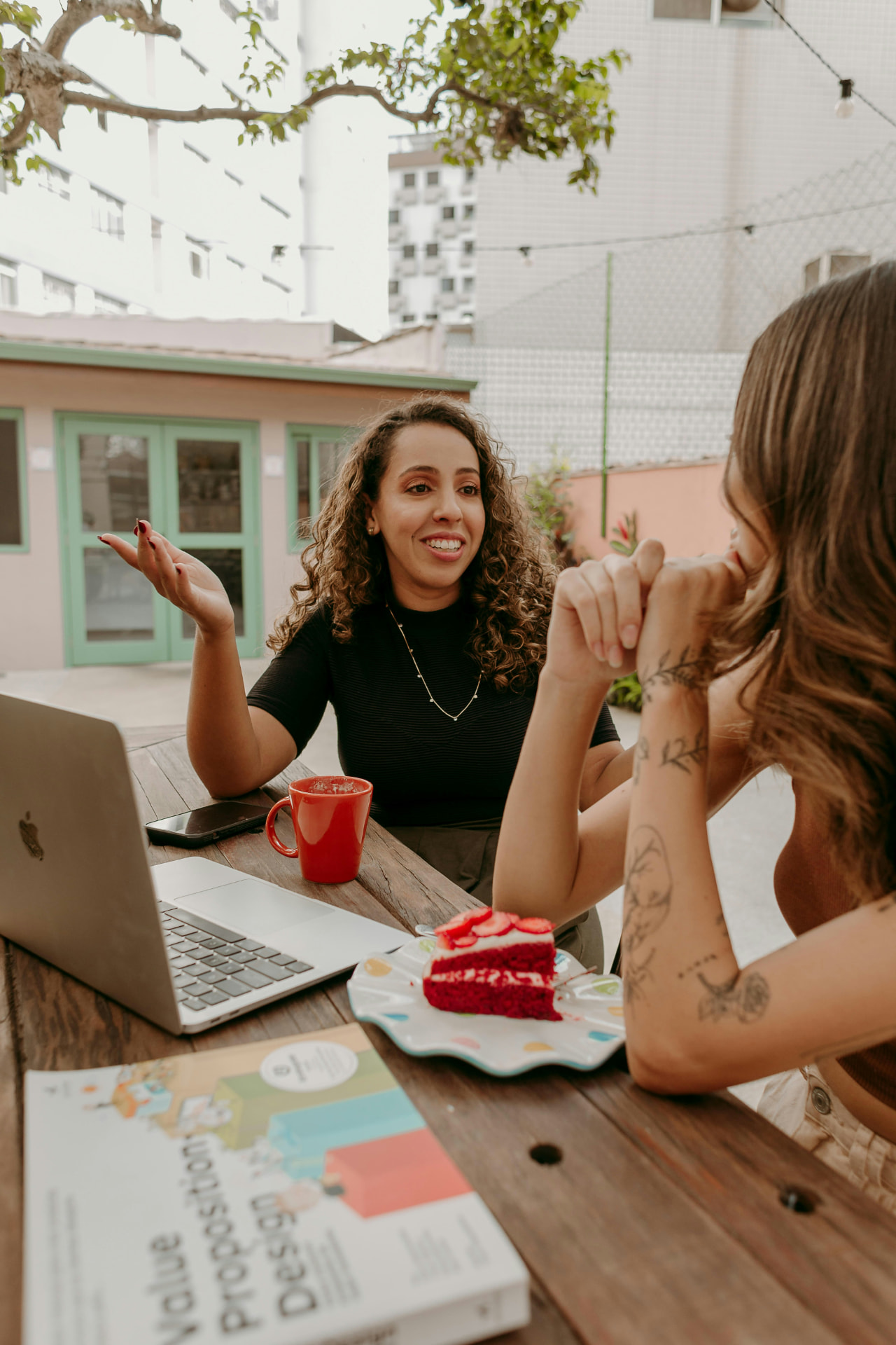 Duas mulheres conversando sobre negócios em uma mesa com laptop